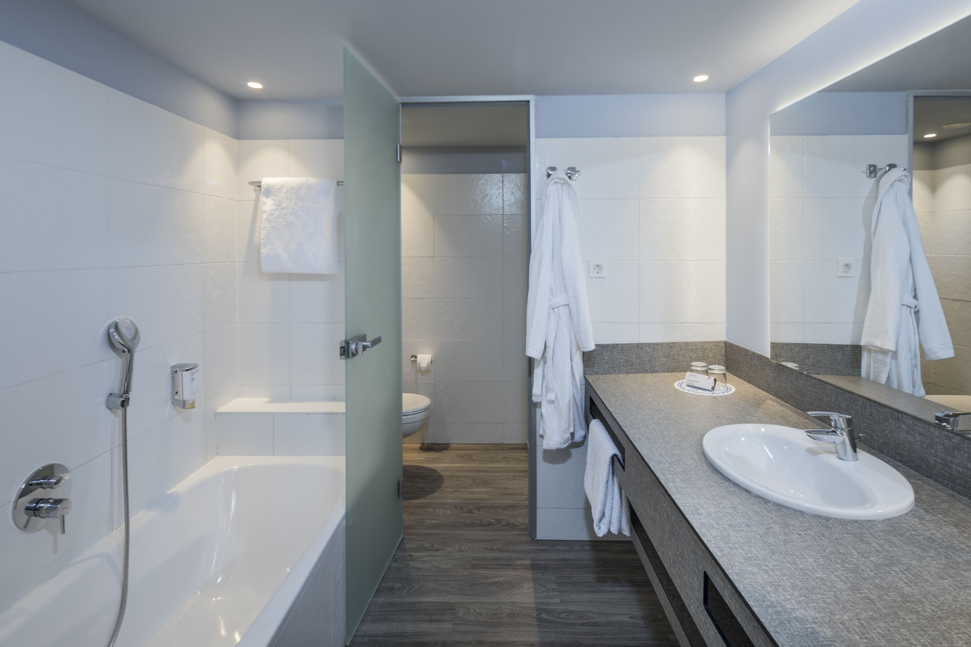 A modern bathroom with a bathtub, a sink, and a toilet.