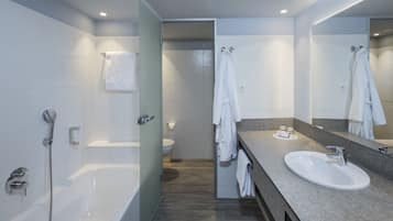 Un baño moderno con bañera, lavamanos e inodoro.