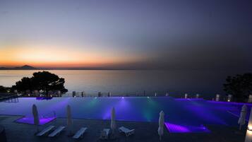 Una piscina infinita con vistas al mar al atardecer.