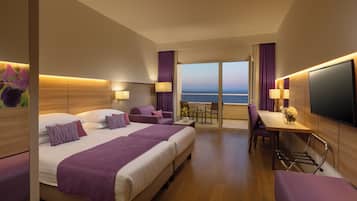 Camera d'albergo con un letto grande, una scrivania e vista mare.