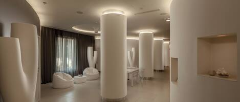 A modern hotel lobby with high ceilings, large white columns, and a minimalist design.