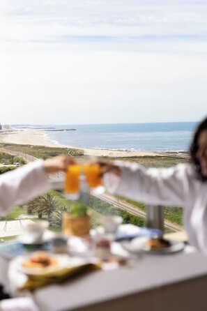 A dining table with breakfast items and a view of the beach and ocean. - Hotel Solverde Spa & Wellness Center (Vila Nova de Gaia)