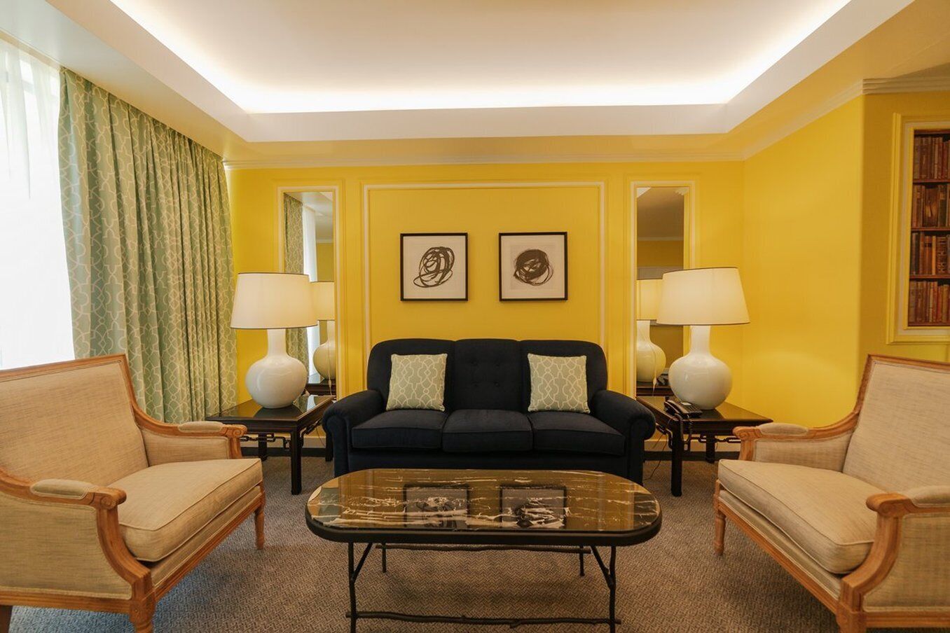 A living room with a sofa, two armchairs, a coffee table, and two lamps.