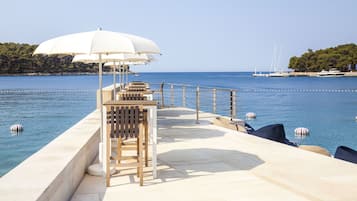 Een privéstrand, ligstoelen aan het strand, parasols, motorbootverhuur