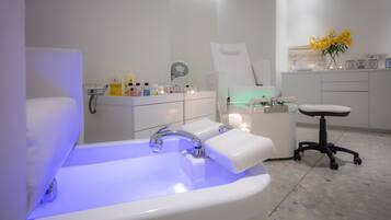 A modern bathroom with a white sink, a large mirror, and a white chair.