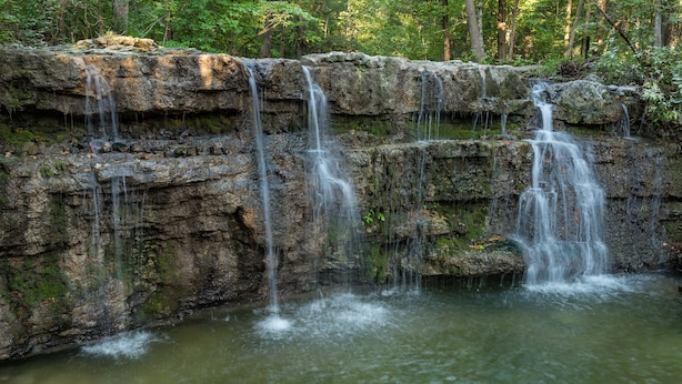 Une cascade naturelle qui dévale sur un terrain rocheux.