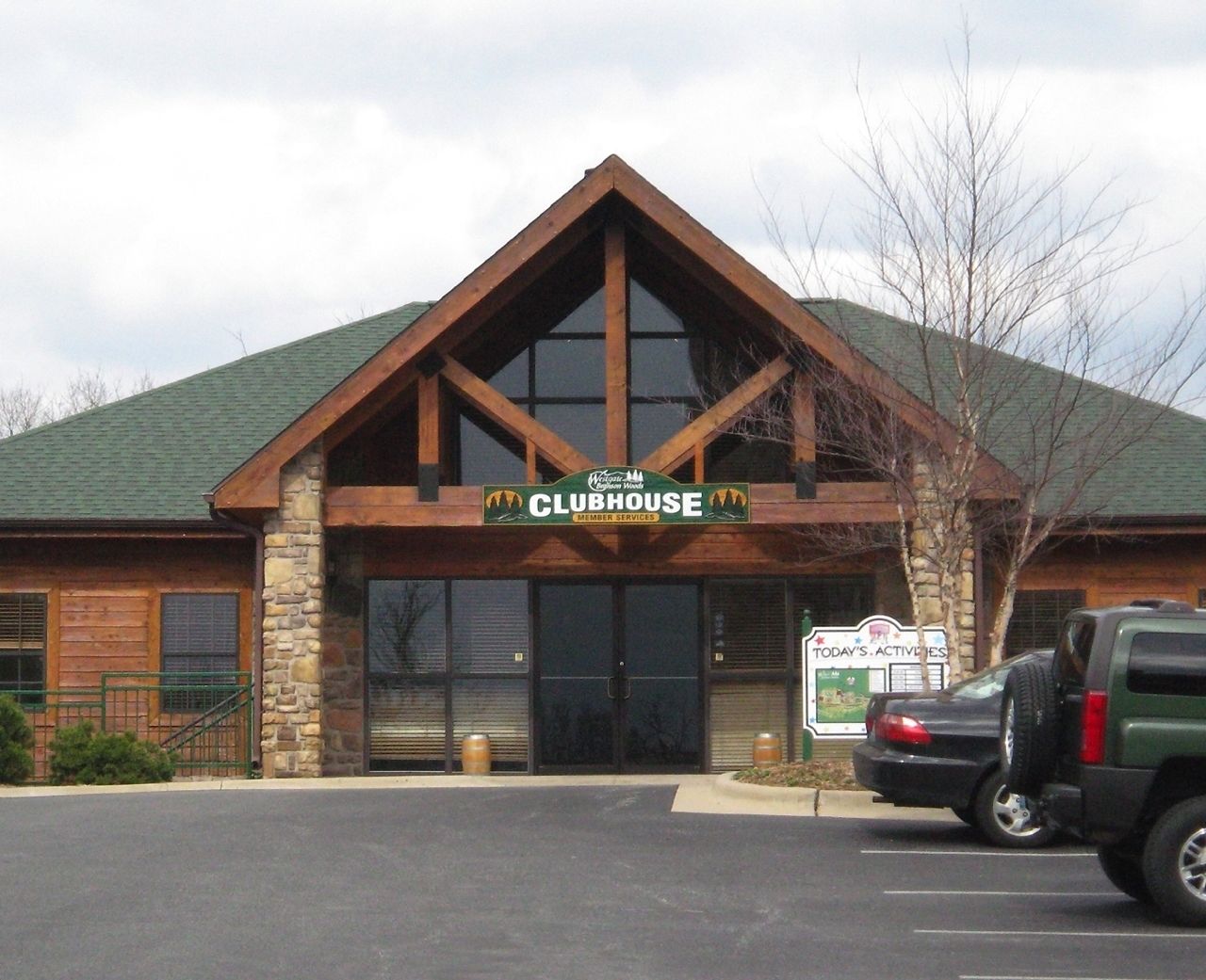 A Clubhouse with a stone facade, wooden beams, and a green roof.