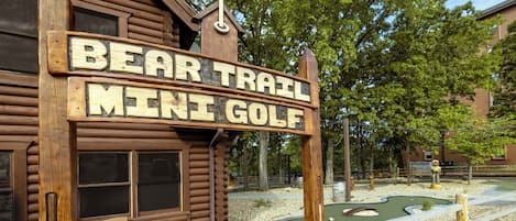 A wooden sign for Bear Trail Mini Golf.