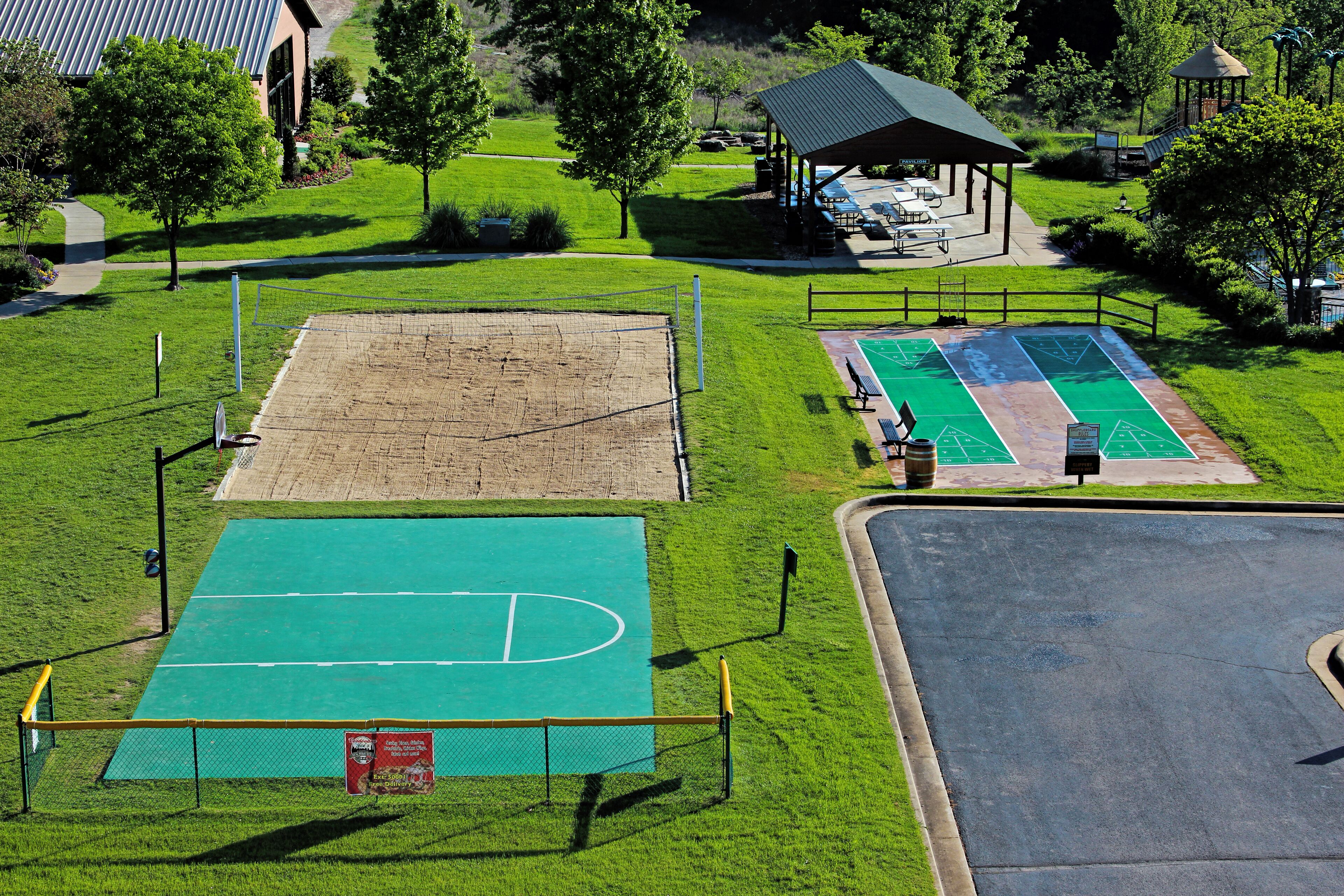 A sports court with a basketball court, a tennis court, and a soccer field.