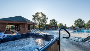 Un espace avec un bain à remous, des chaises longues, une piscine et un coin salon abrité.