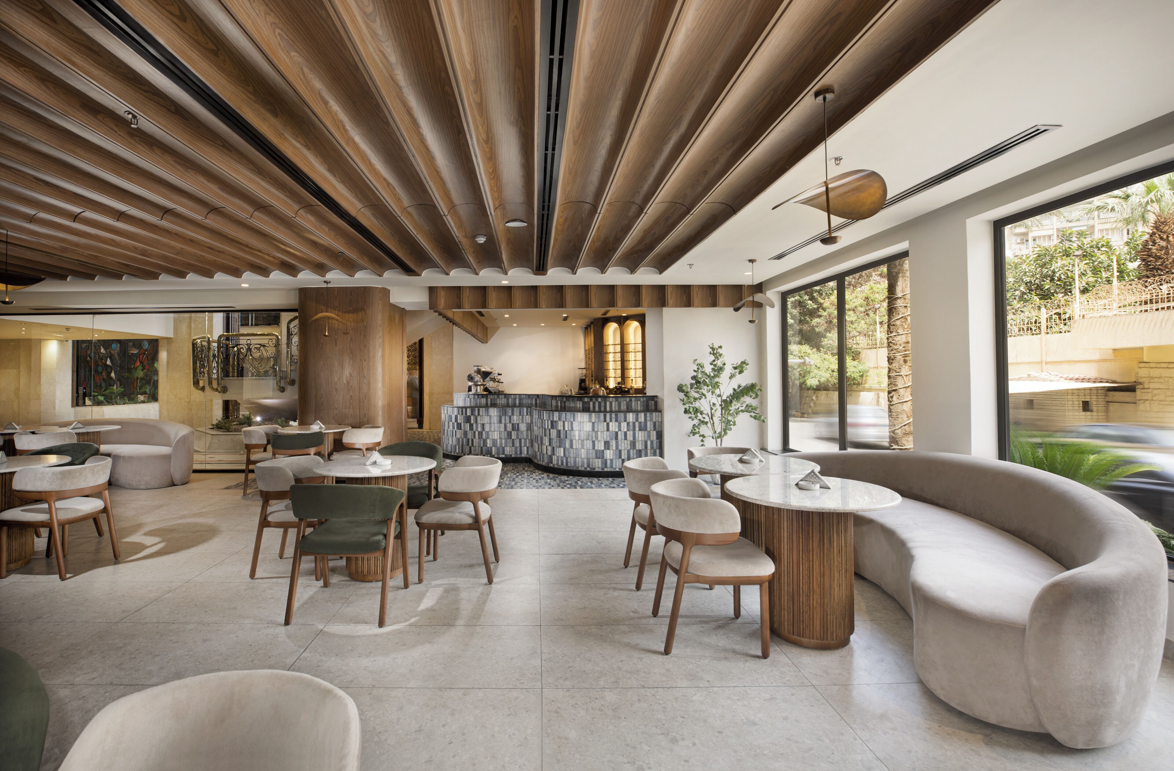 Un interior moderno con paneles de techo de madera, una zona de bar y diferentes distribuciones de asientos.