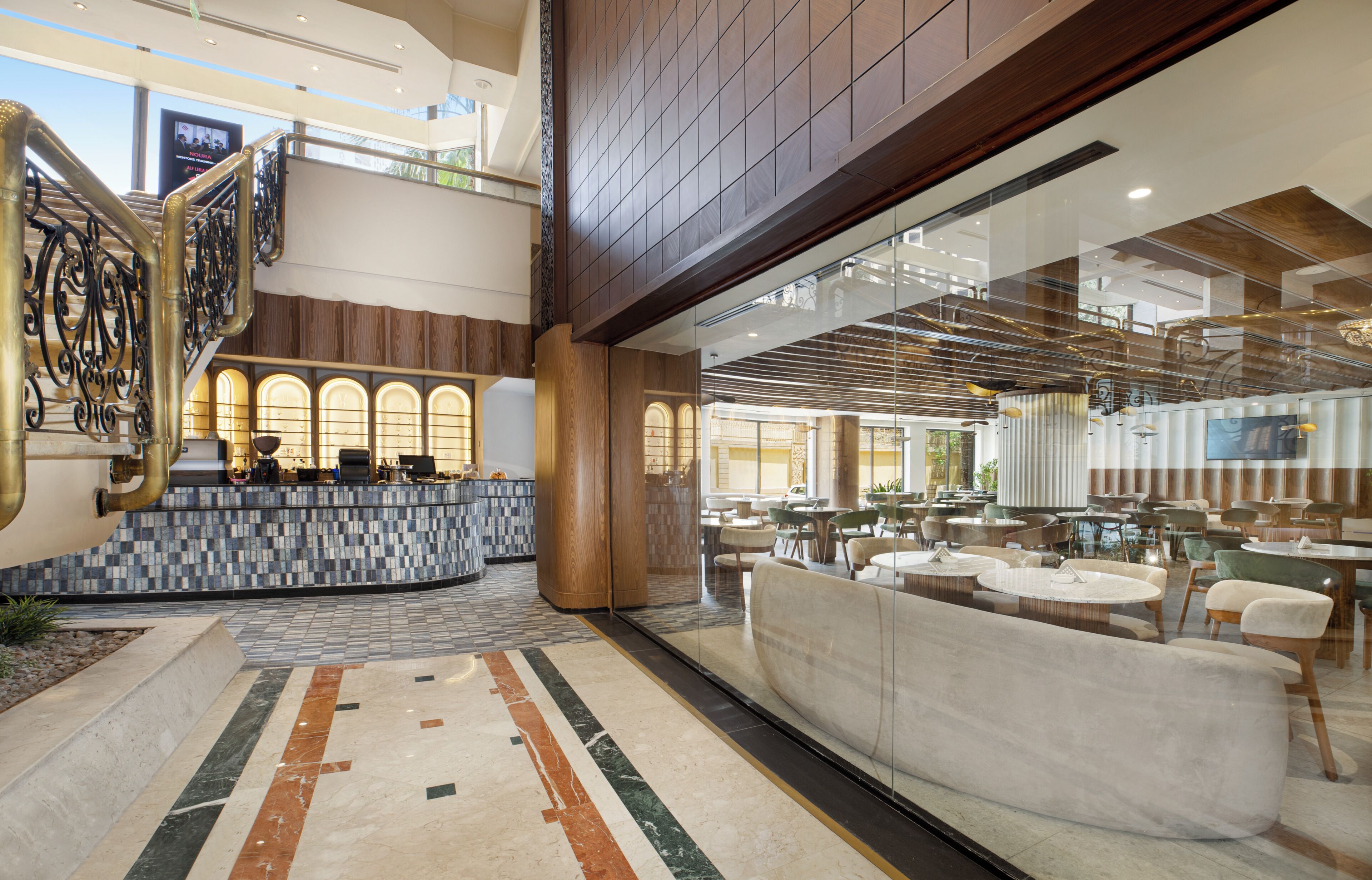 A lobby with a reception desk, seating area, and a staircase.