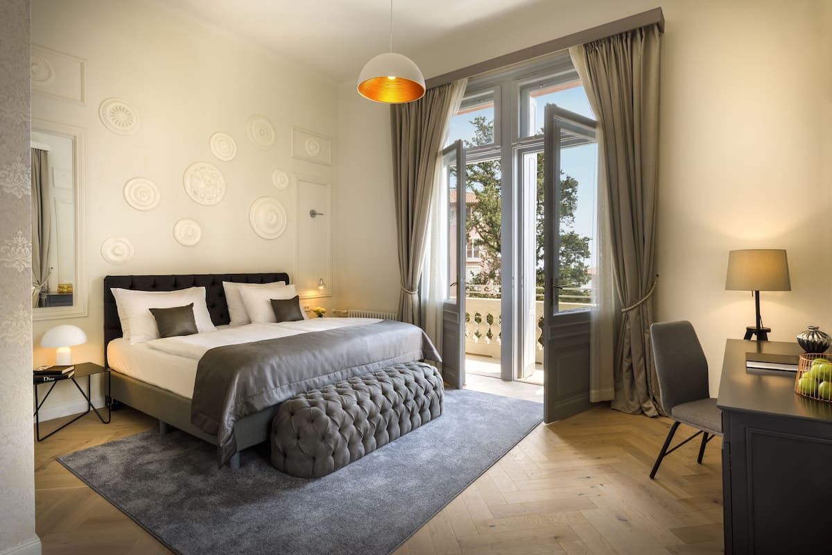 Une chambre moderne avec un grand lit, un bureau et une vue sur l’extérieur.