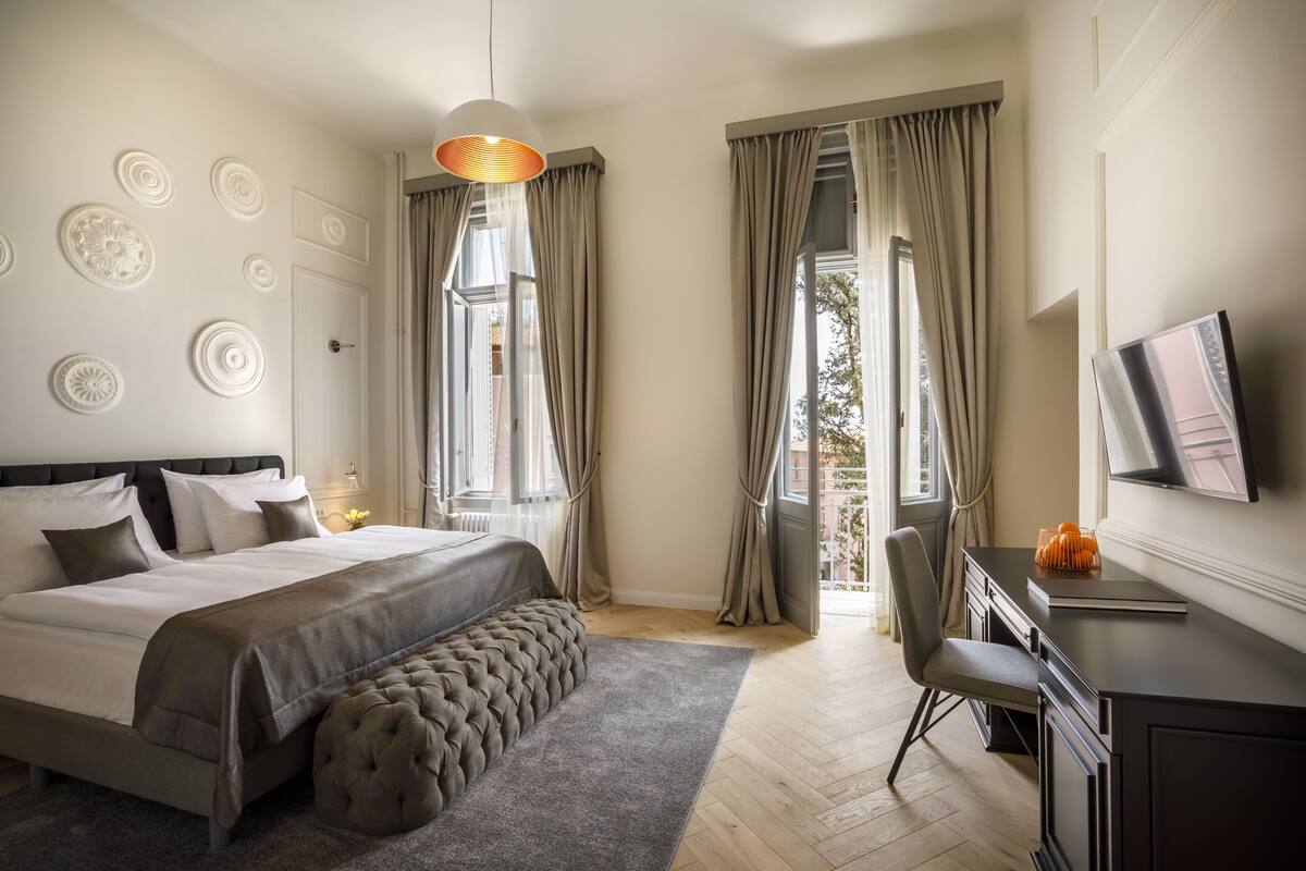 Une chambre avec un grand lit, un bureau, une chaise et un téléviseur.