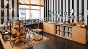 A buffet with various food items, a chandelier, and striped walls.