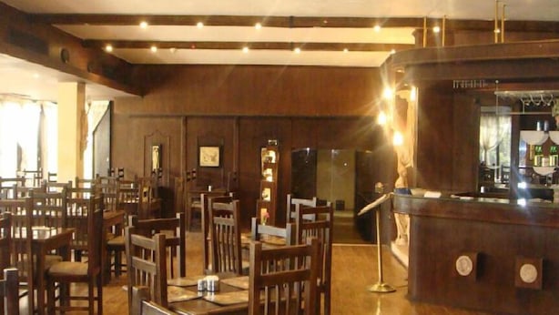 Un restaurant avec des meubles en bois et un coin bar.