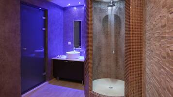 Stylish bathroom with a standalone shower, white sink, and mirror.