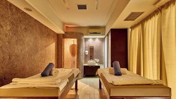 A room with two beds, a sink, and a mirror.