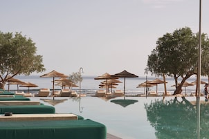 Area piscina con lettini e ombrelloni, vista mare.