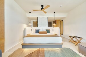 A modern bedroom with a bed, a ceiling fan, and a large mirror.