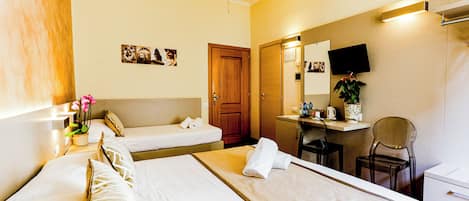A hotel room with two beds, a desk, a chair, a TV, and a bathroom.
