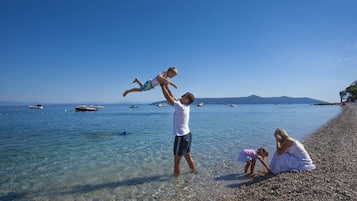 In Strandnähe, weißer Sandstrand, Liegestühle, Sonnenschirme