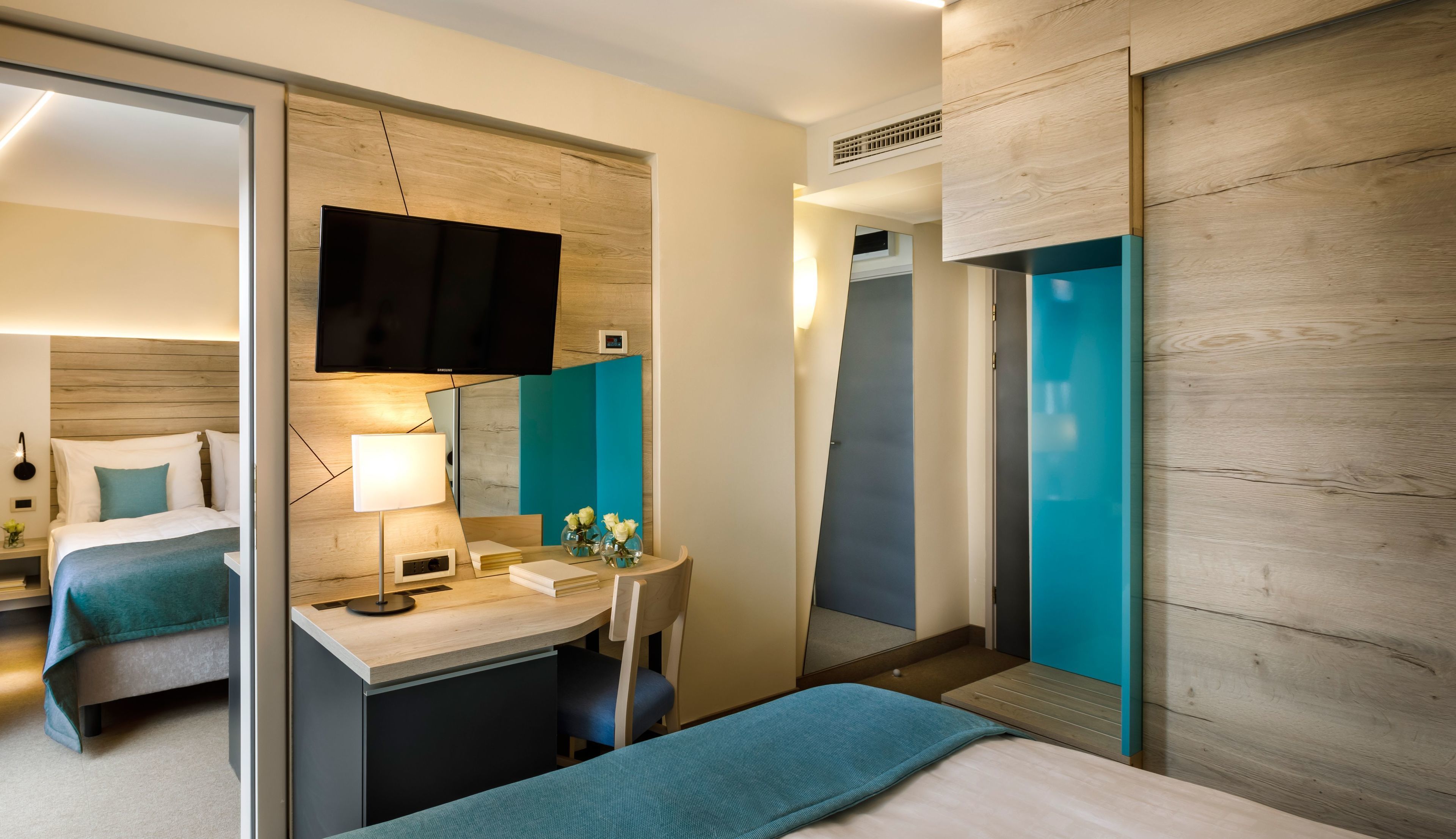 Une chambre d’hôtel moderne équipée d’un lit, d’un bureau et d’une télévision.