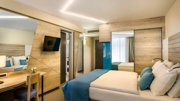 Una habitación de hotel moderna con cama, escritorio, silla y un espejo grande.