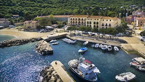 A coastal town with a marina, boats, and buildings along the waterfront.