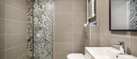 A modern bathroom with a shower, toilet, and sink.