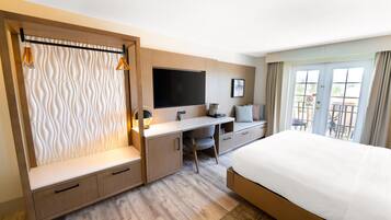 A modern hotel room with a bed, desk, and seating area.