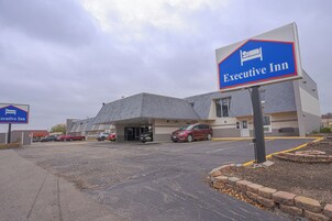 Un estacionamiento con un edificio que dice "Executive Inn".