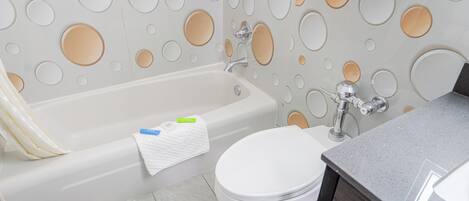 A bathroom with a bathtub, toilet, and a sink.