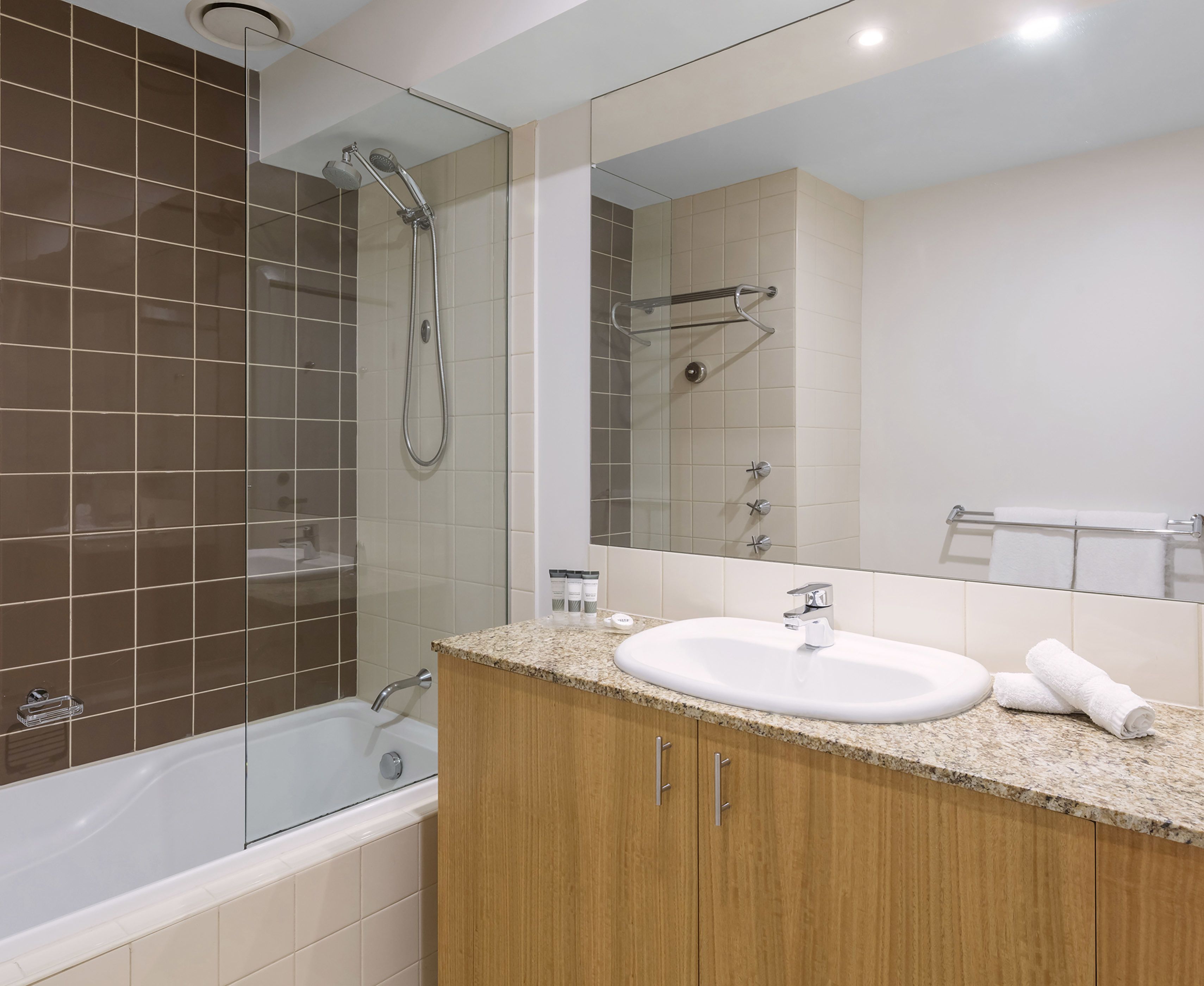 A modern bathroom with a bathtub, a shower, a sink, and a vanity.