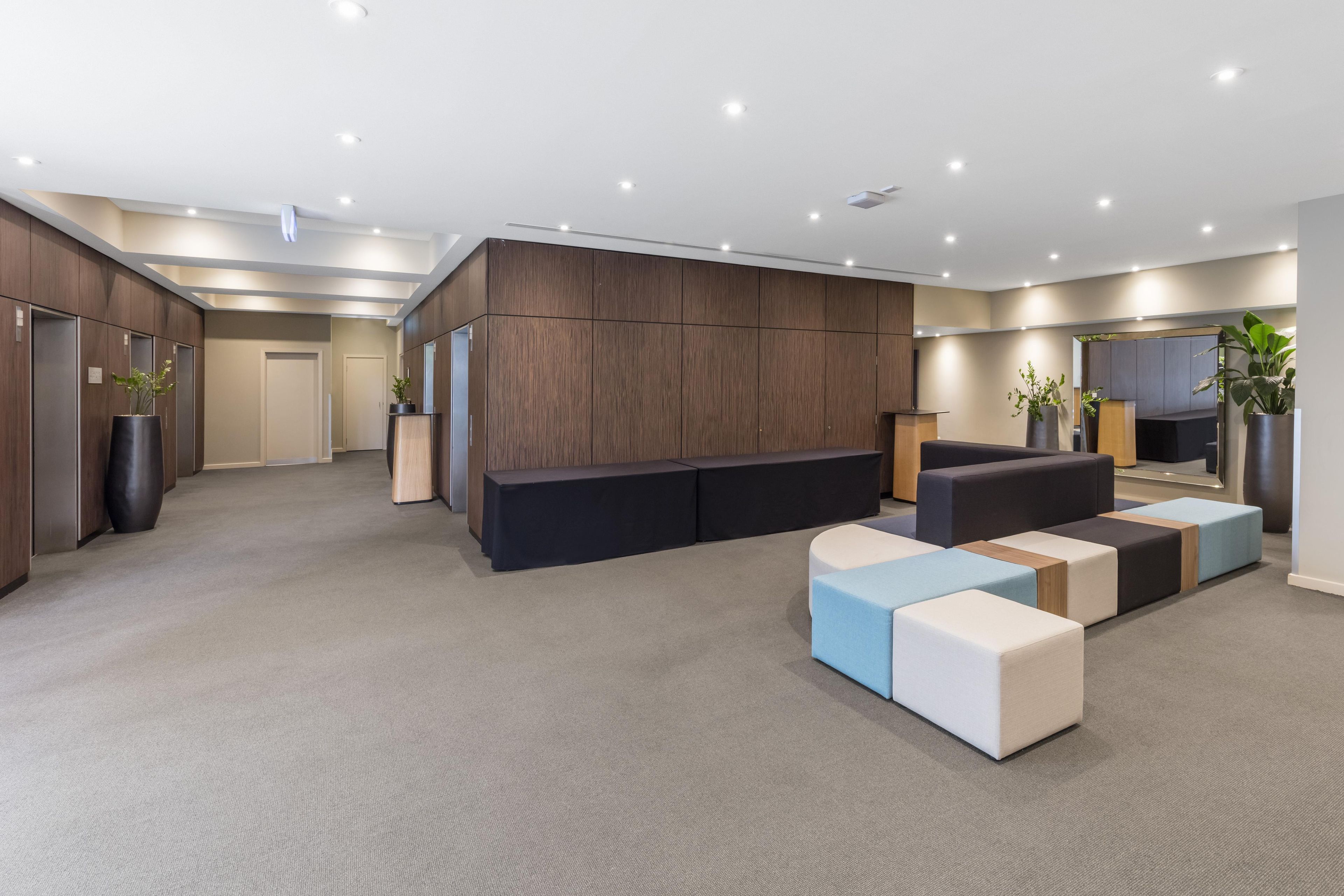 A modern living room with a sectional sofa, a flat-screen TV, and built-in wooden cabinets.