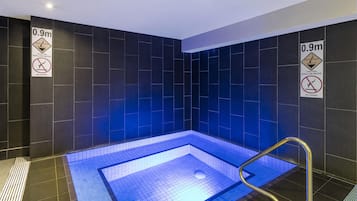 A small, rectangular pool with a 0.9m depth warning sign on the walls.