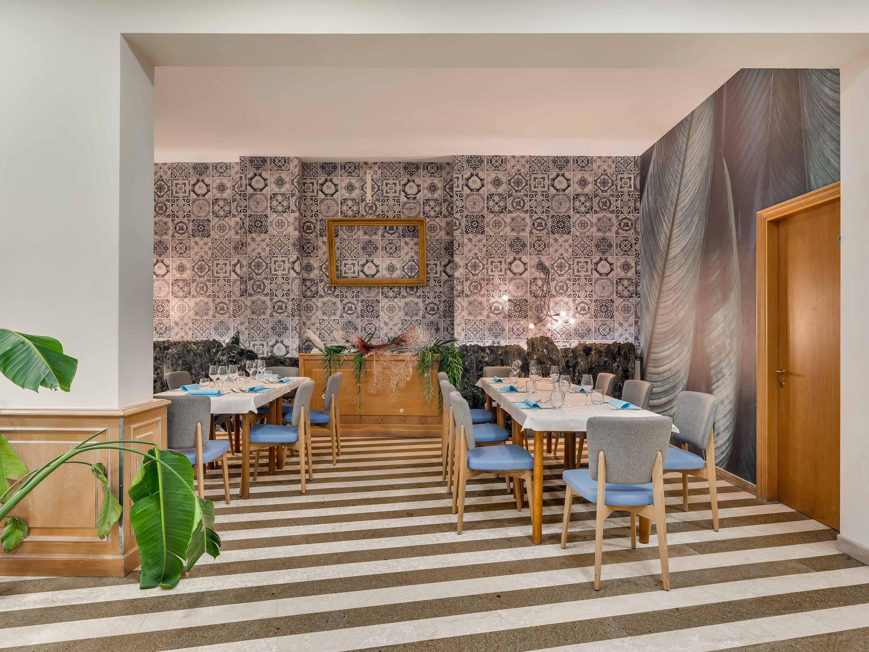 Un coin repas agrémenté d’un mur à motifs, d’un tableau encadré et d’une grande peinture.