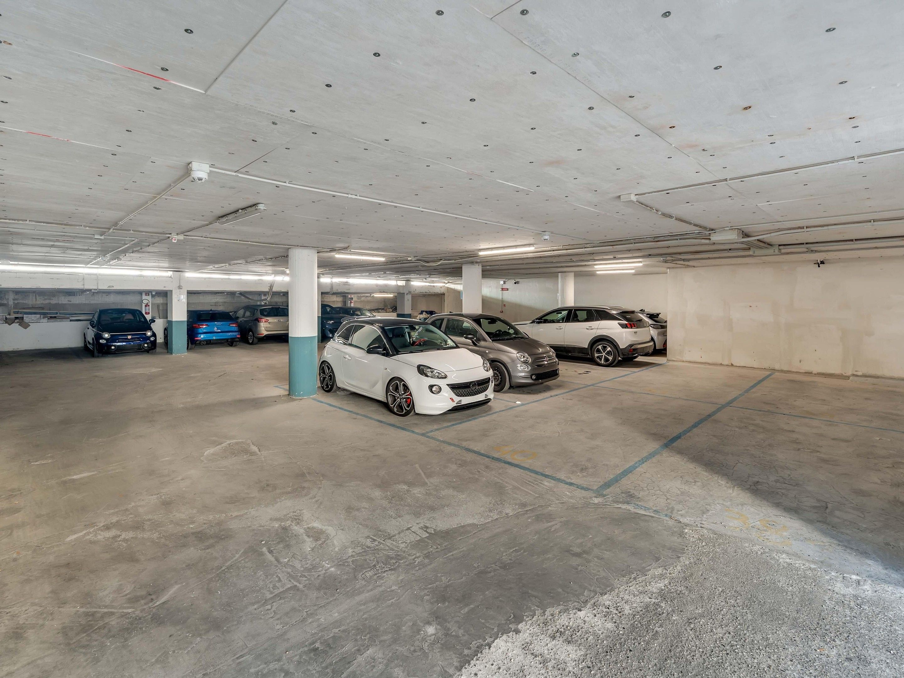 Un estacionamiento con varios niveles y varios coches aparcados.