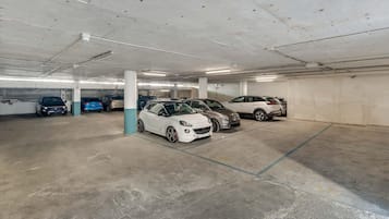 Un estacionamiento con varios niveles y varios coches aparcados.