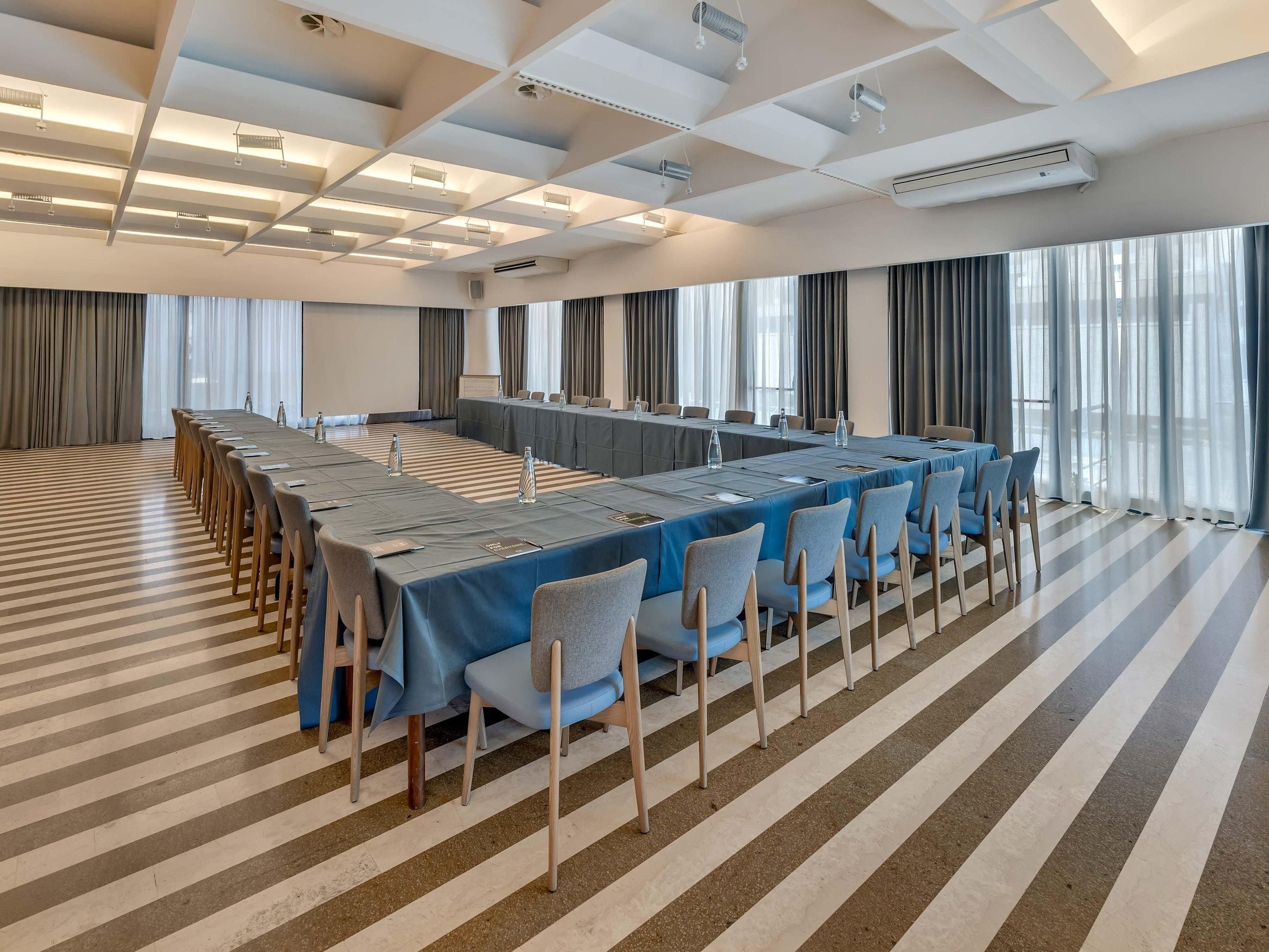Une salle de conférence équipée d’une longue table, de chaises et d’un écran de projection.