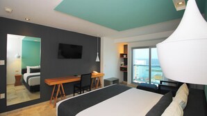 Een moderne hotelkamer met een groot bed, een bureau en een televisie.