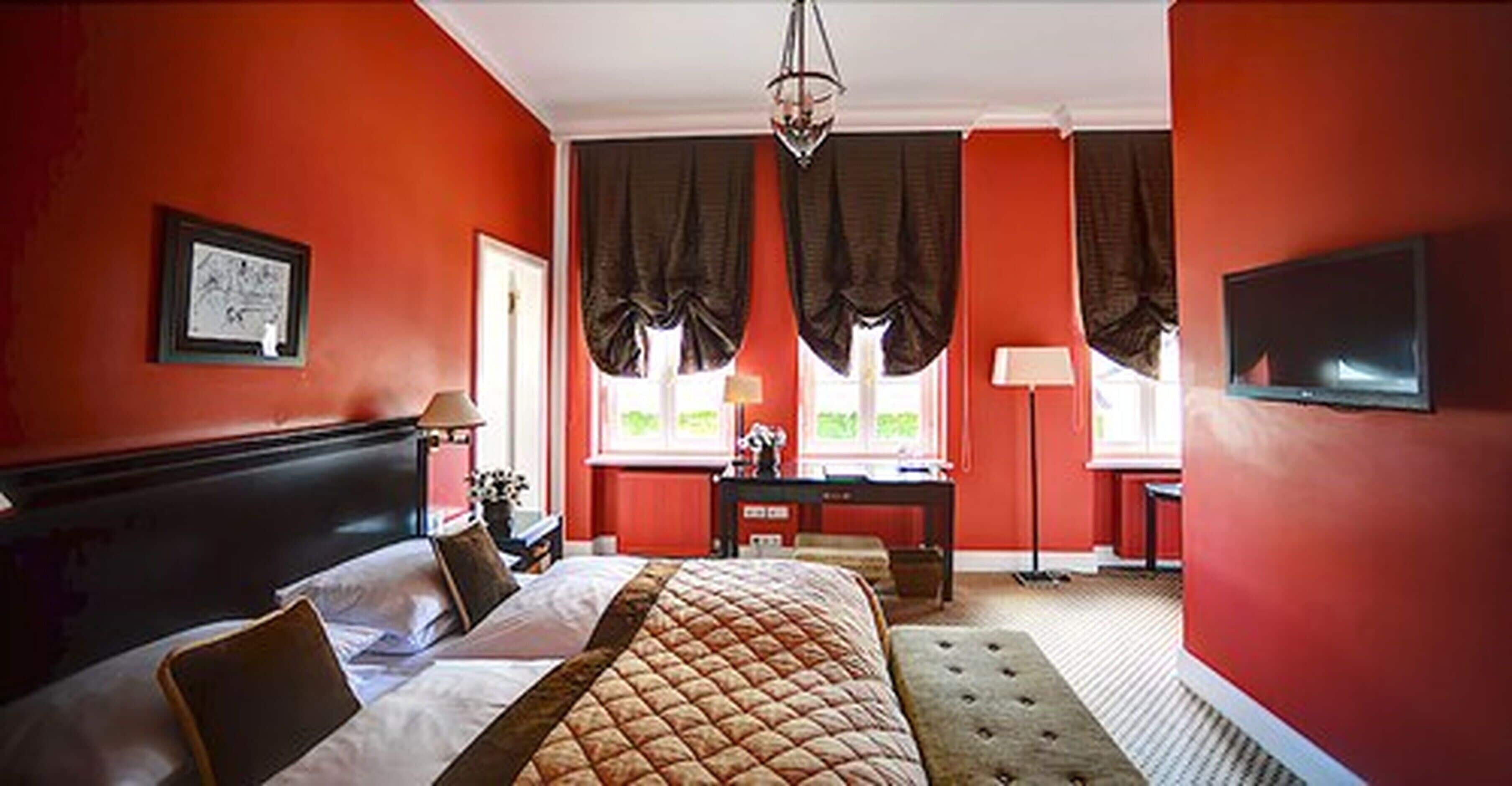 A hotel room with a large bed, a desk, and a television.