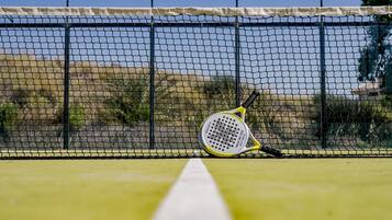 A tennis court with a net and a tennis racket leaning against it.