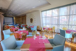 A restaurant with multiple tables and chairs, a large mirror, and a view of the outdoors. - Hotel Valle del Este Golf Spa (Vera)