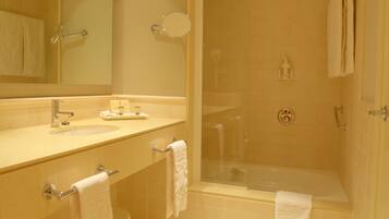 Un baño moderno con lavamanos, espejo y bañera.