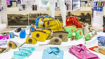 Diversos bolsos y prendas de vestir exhibidos sobre una mesa en una tienda.