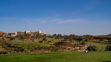 A golf course with a large building in the background.