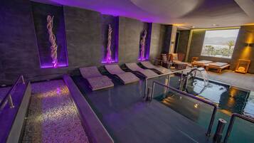 A modern spa area with a pool, seating, and a view of the outdoors.