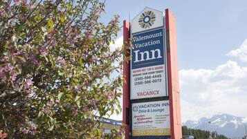 Señal del Vacation Inn de Valemount que anuncia bañera de hidromasaje y sauna interiores, disponibilidad de habitaciones y números de contacto.