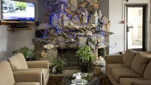 A living room with a stone fireplace, a television, and two sofas.